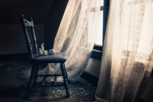 baby doll in a chair in an abandoned attic 