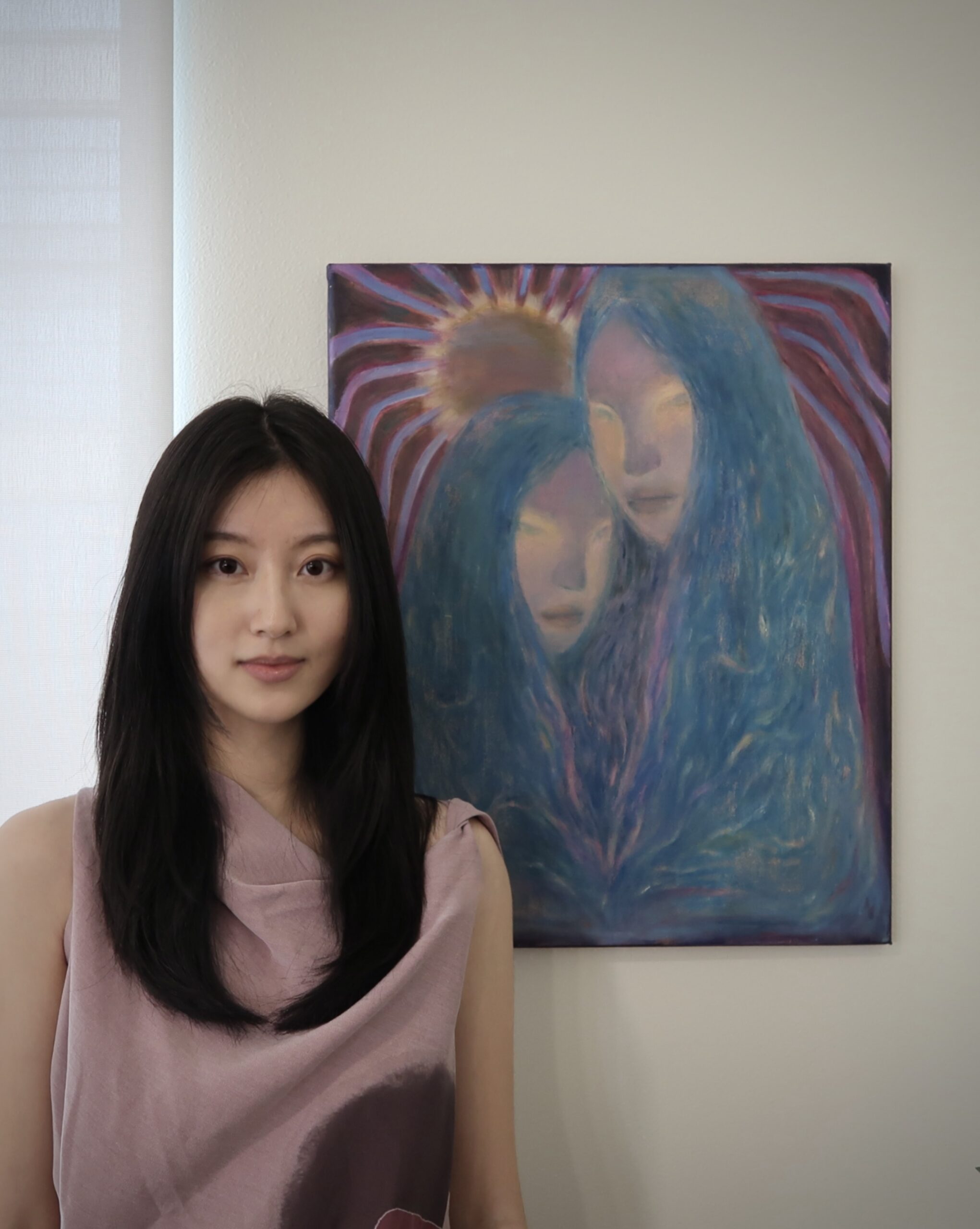 Siting Wang poses next to portrait painting.