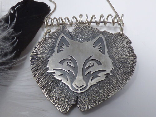 reverse of pendant with raven and wolf design