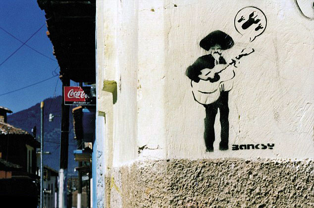 Banksy stencil of a figure on a pale wall in Mexico with a balloon-like outline
