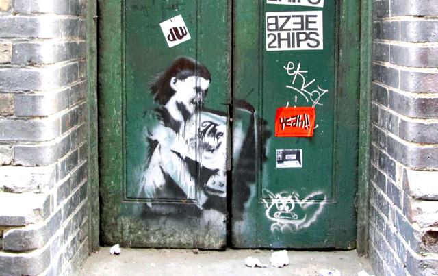Banksy Girl Hugging TV stencil painted on a doorway in Covent Garden London