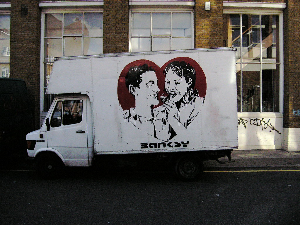 Banksy painted removal van with two smiling figures inside a red heart