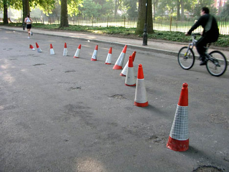A line of altered orange traffic cones across a road in the Banksy archive
