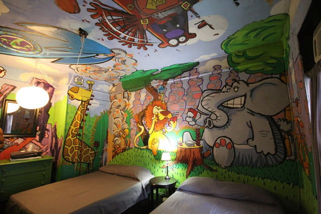 Colourful cartoon painting across walls and ceiling at the Carlton Arms Hotel