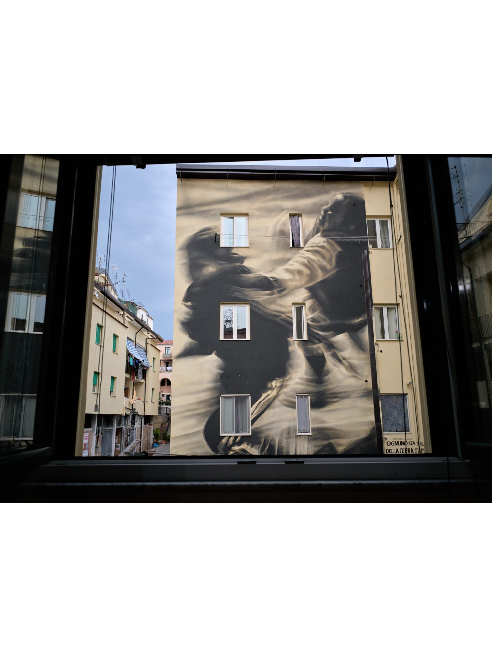 Photo by Guido van Helten on October 01, 2026. May be an image of street, window, buildings and text.